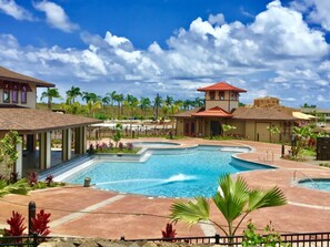 Ein Resort mit großem Pool, Palmen und blauem Himmel.