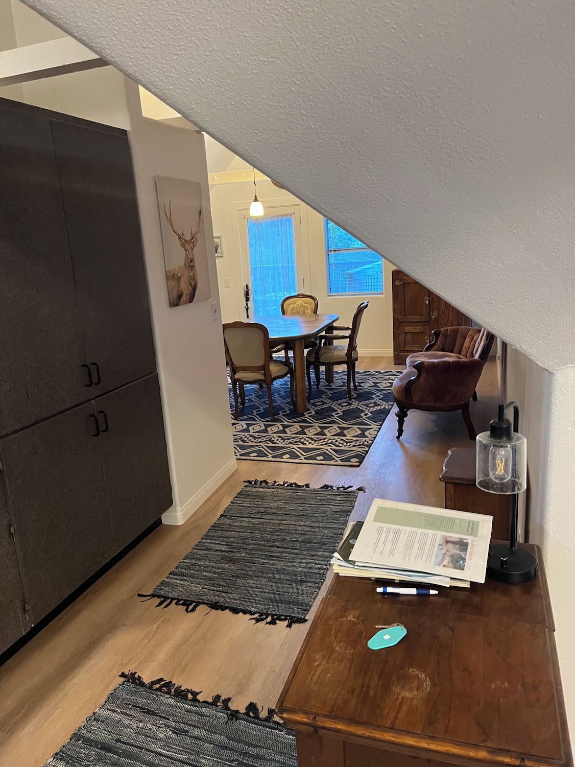 Quarto aconchegante com área de refeições, um armário de madeira e um tapete.