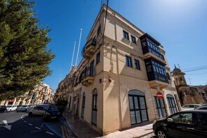 Un immeuble à plusieurs étages, de style architectural classique, doté de balcons et de grandes fenêtres.