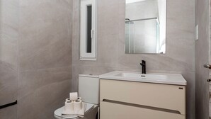 Un baño moderno con inodoro, bidé y lavamanos.