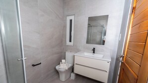 Une salle de bain avec des toilettes, un lavabo et un miroir.