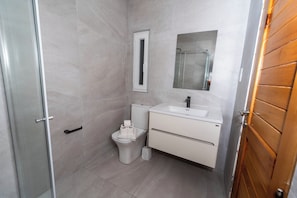 Un bagno con WC, lavandino e specchio.