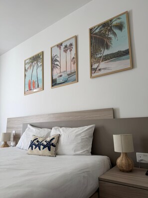 A hotel room with a bed, two bedside tables, and three framed pictures on the wall. - Exlcusive 2 bedroom penthouse private terrace poll (Il-Mellieħa)