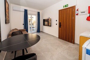 Ein Zimmer mit einem runden Tisch, einer Couch, einer Tür und einem Feuerlöscher.