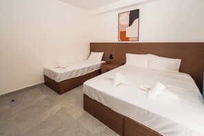 Une chambre d’hôtel avec deux lits, une tête de lit en bois et un tableau au mur.