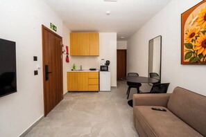 Ein modernes Interieur mit einer Küchenzeile, einem Essbereich und einer Couch.