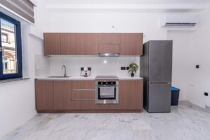 Una cucina moderna con mobili in legno, forno in acciaio inox e lavastoviglie integrata.