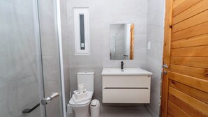 Une petite salle de bain comprenant des toilettes, un bidet, un lavabo et un miroir.
