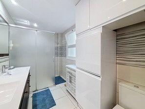 A modern bathroom with a white sink, mirror, and toilet. - DRASSANES Rosas / Roses – INTERimmo (Rosas / Roses)