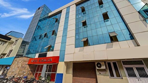 A modern building with a glass facade, a red sign indicating a hotel, and a closed shuttered entrance. - GSILVER HOTEL HIMALAYA (Chennai)