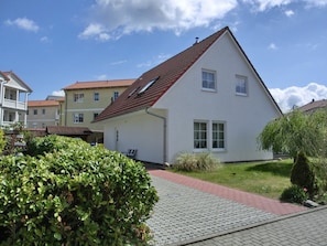 A single-story house with a red-tiled roof, a front porch, and a paved driveway. - Holiday Home in Graal-muritz With Terrace (Graal Mueritz)