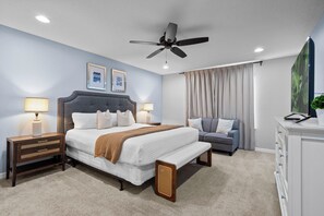 A bedroom with a bed, bedside tables, a sofa, a ceiling fan, and a TV. - 5BR Townhome Steps from Clubhouse near Disney! (Kissimmee)