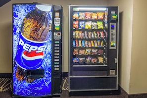 Two vending machines, one with a Pepsi logo and the other with a variety of snacks.