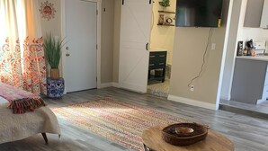 Een woonkamer met een bank, een poef en een salontafel.