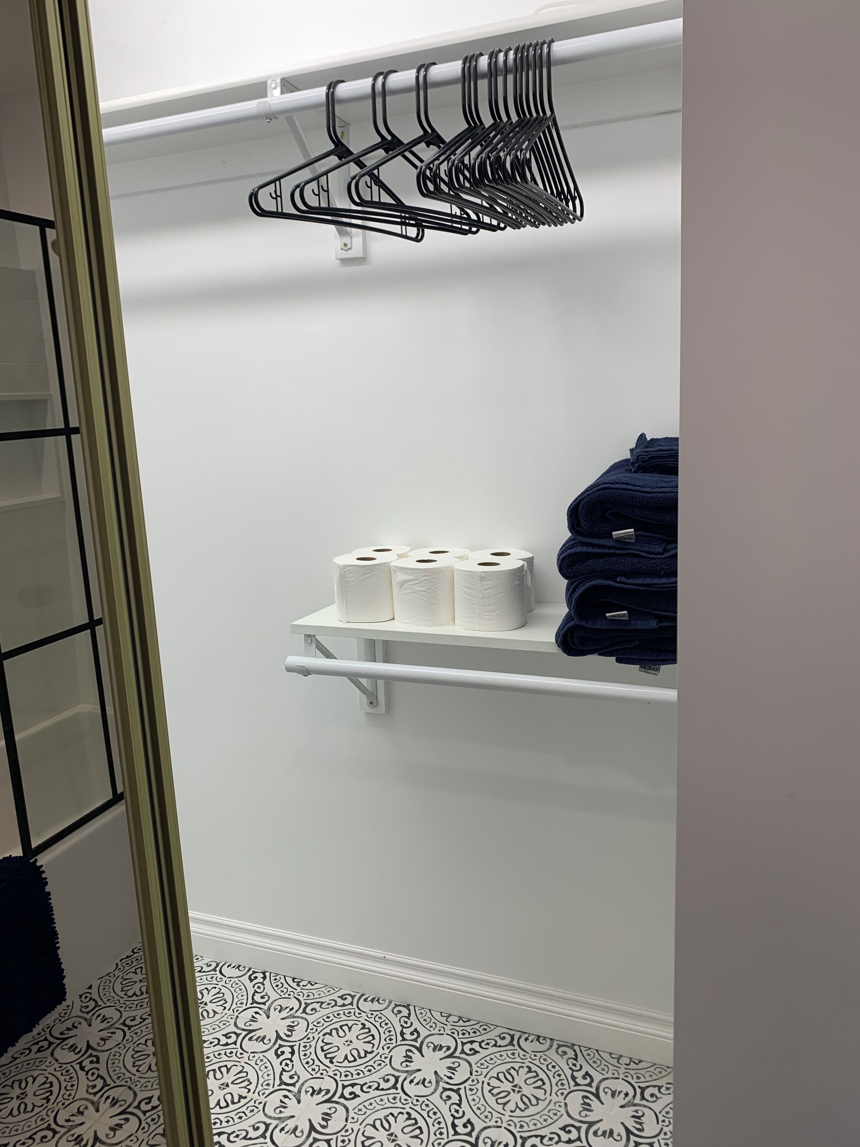 A closet with shelves holding towels and toilet paper.