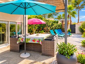 An outdoor patio with a table and chairs, a large umbrella, and a potted plant. - Villa Bord De Mer* chez roselyne* shops and beach on foot* private garden, parking, Wi-Fi (Saint-Cyprien)