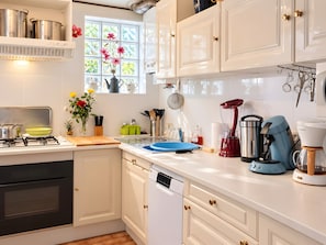 Une cuisine moderne avec des meubles blancs, des appareils en acier inoxydable et une fenêtre offrant une belle vue.