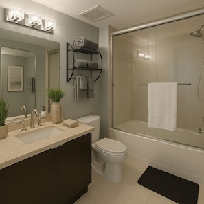 A modern bathroom with a glass-enclosed shower, a toilet, a sink with a mirror, and a towel rack. - 3BR Edgewater High Rise Bay & Skyline Views (Miami)