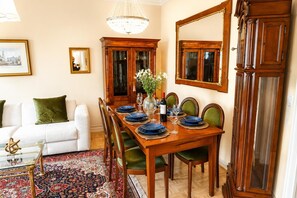 Ein Esszimmer mit einem Holztisch, gedeckt für vier Personen, umgeben von Stühlen.