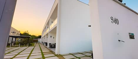 A modern building with a flat roof, a visible number '940' on the side, and a paved pathway leading to the entrance.