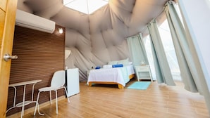 Ein Zimmer mit einem Bett, einem kleinen Tisch und einem Stuhl.