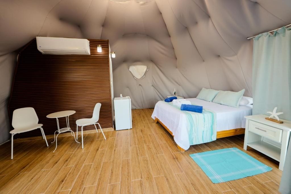 Een slaapkamer met een bed, nachtkastje en een stoel.