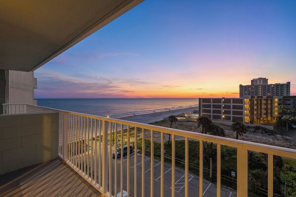 Ein Balkon mit Blick auf Strand und Parkplatz.