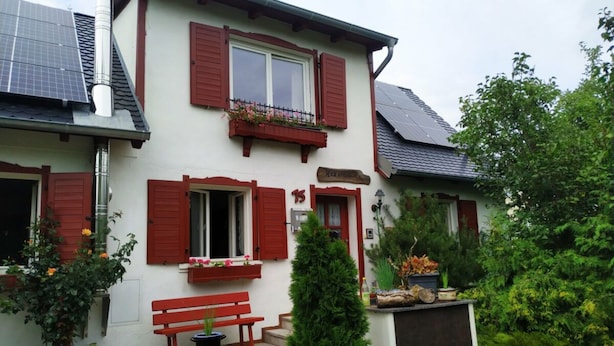A two-story house with red shutters, a bench, and potted plants. - Hex"nhausla in Aufsess (Aufsess)