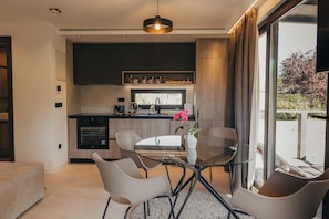 A modern kitchen with dark cabinetry, a built-in oven, and a coffee machine. - Luxury Forest Retreat With Pool Access (Karlovac)