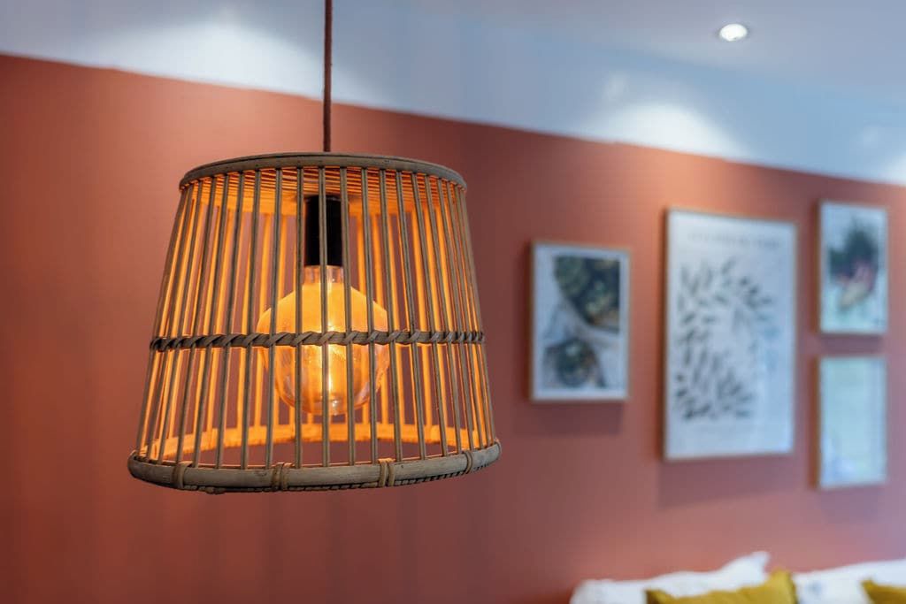 A hanging light fixture with a cylindrical design and a visible bulb.