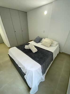 A bedroom with a bed, pillows, a bedside table, and a wardrobe. - Private apartment ideal for working, Downtown Medellín (Medellín)