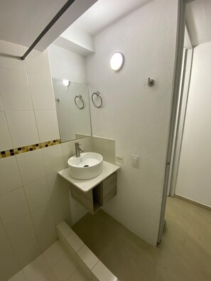 A bathroom with a white sink, mirror, and towel rings. - Private apartment ideal for working, Downtown Medellín (Medellín)