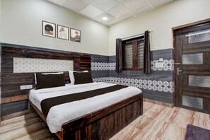 A bedroom with a bed, a headboard, a window with curtains, and a door. - Hotel O Mathura Janam Bhumi Link Road (Mathura)