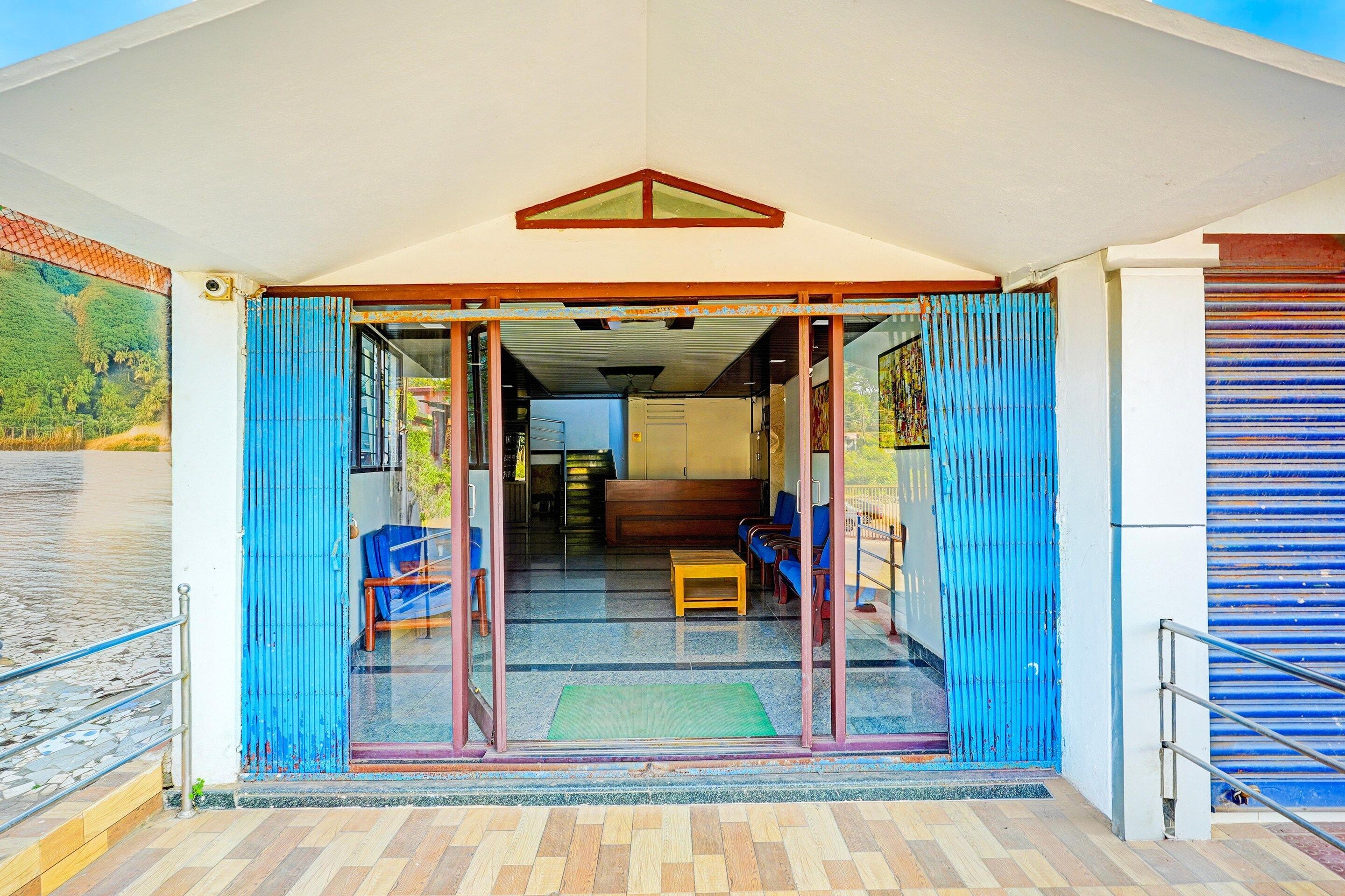 A building entrance with a glass door, a bench, and a small table inside.