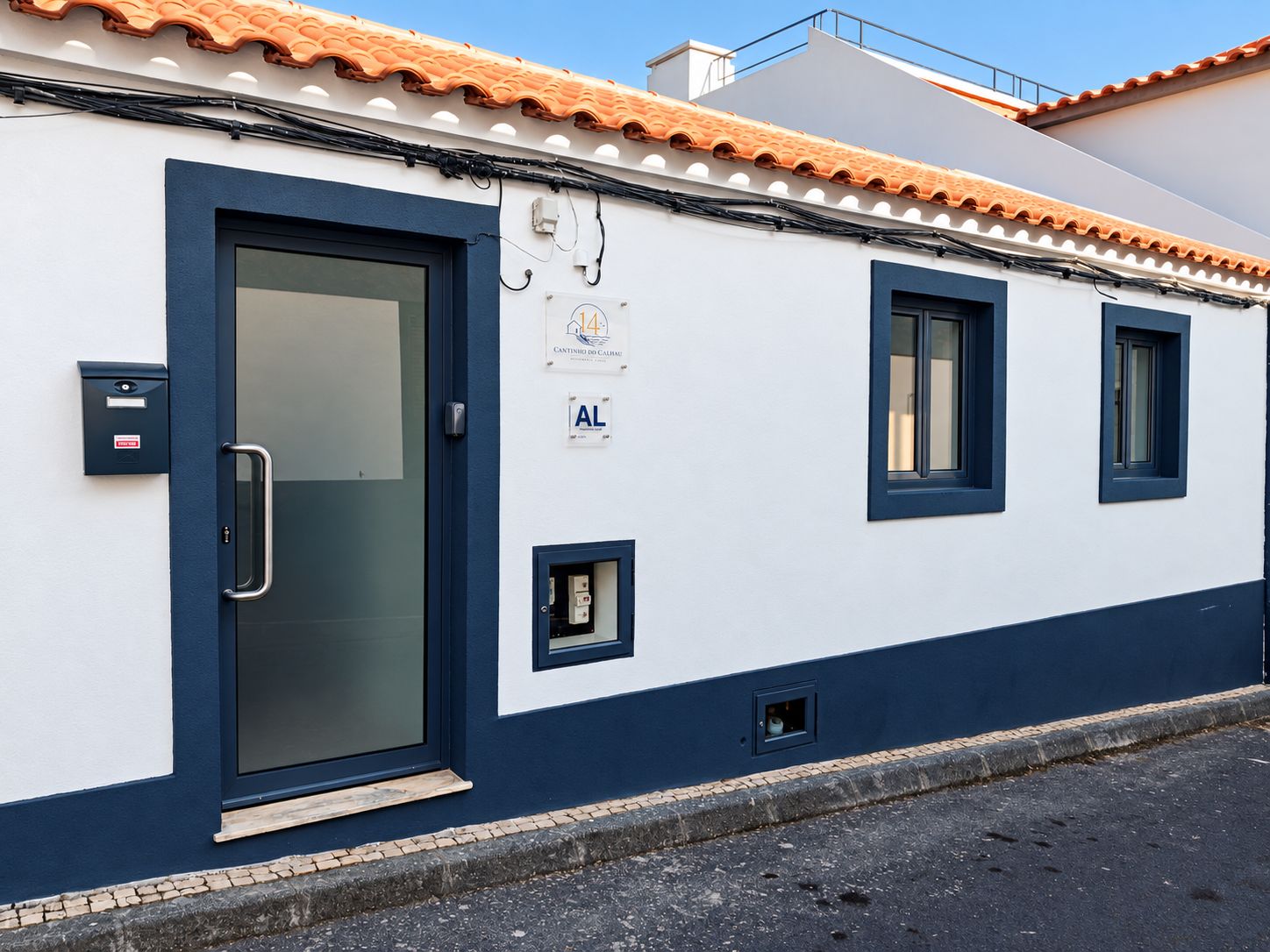Un edificio con una puerta azul, un buzón y un cartel con el número 4.