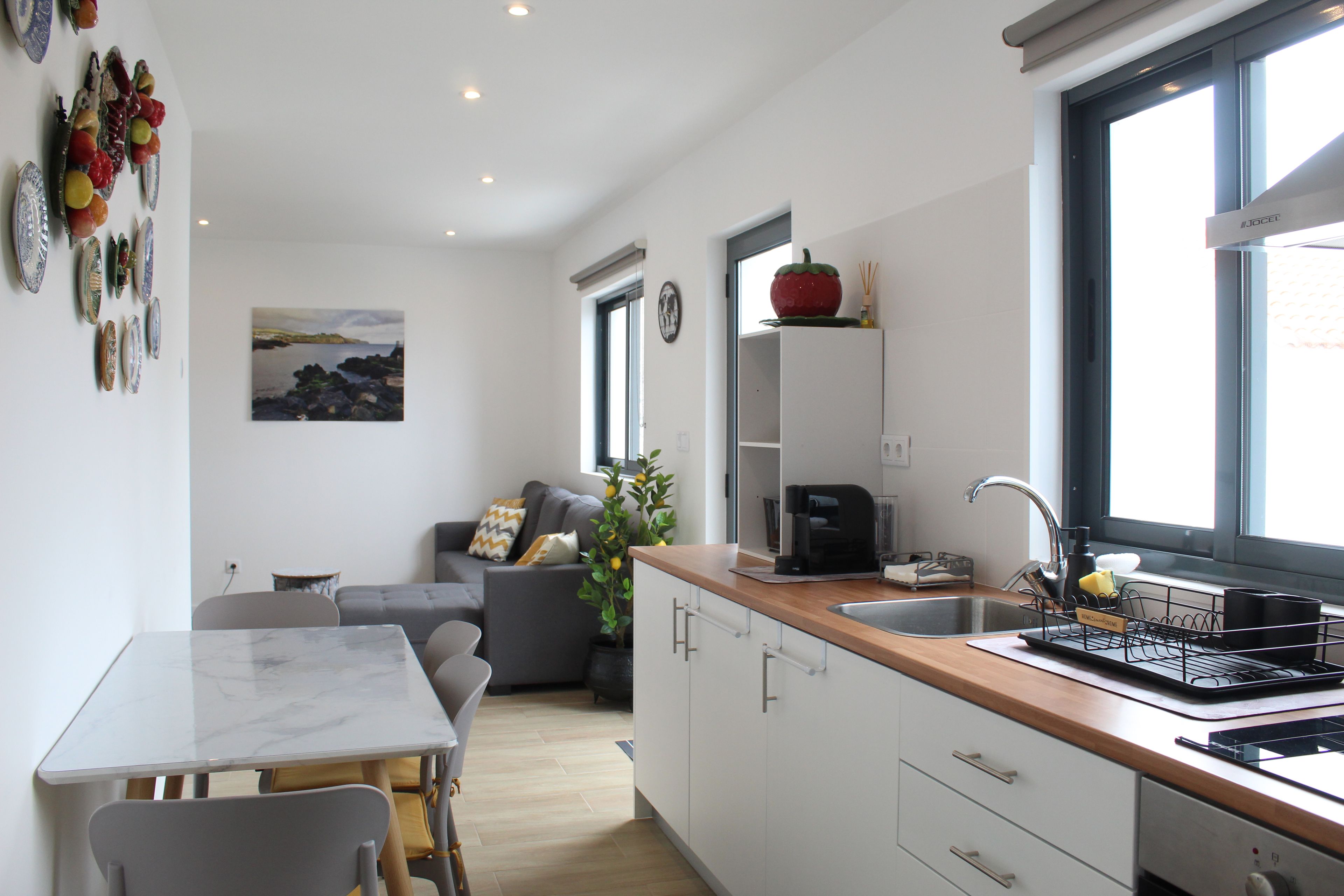 Una cocina moderna con comedor, sofá y vistas al exterior.