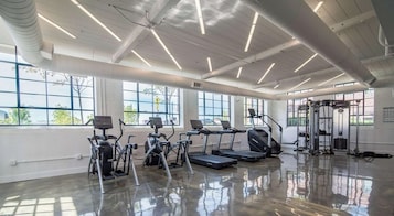 Un gimnasio con cintas de correr, elípticas y una zona de pesas.