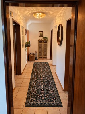A hallway with a patterned rug, a decorative ceiling light, and a traditional door. - Romantic, Renovated Baierweiher Hunting Lodge in Neubäu am See (Roding)