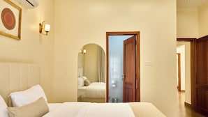 A hotel room with a bed, a wooden door, and a bathroom visible through an archway. - Kibo Homes Arusha (Arusha)