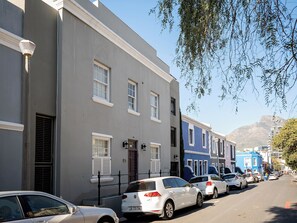 A row of parked cars along a street with buildings on either side. - De Waterkant Guest Suites - WS03 (Cape Town)