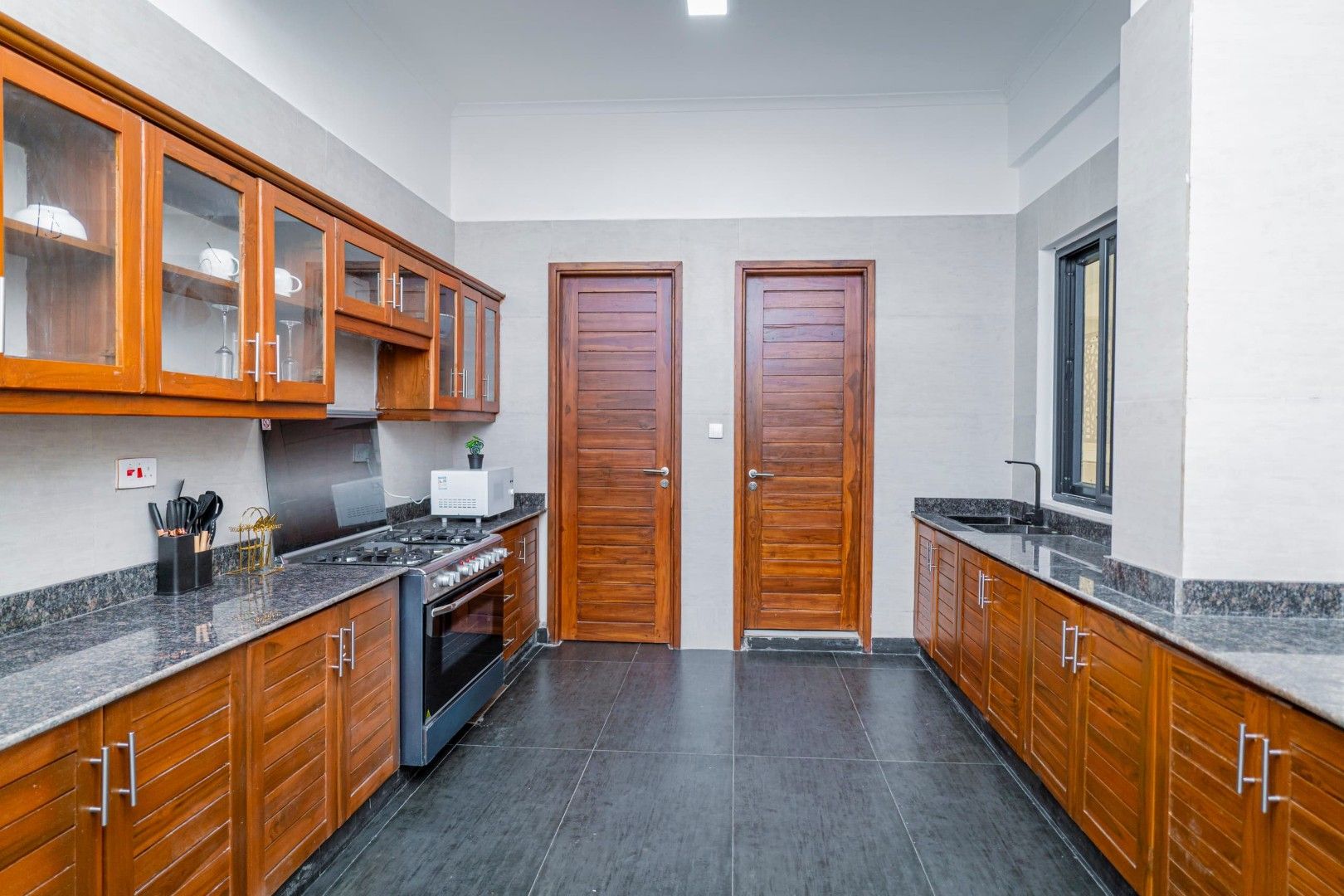 Una cucina con mobili in legno, un fornello e una finestra.
