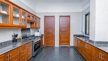 Una cucina con mobili in legno, un fornello e una finestra.