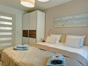 Ein Hotelzimmer mit einem Bett, einem Kleiderschrank, einem Gemälde und einer Tür mit Milchglasfenster.
