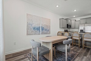 A modern kitchen with grey cabinets, a built-in microwave, and a stainless steel refrigerator. - The Cove-3-bedroom townhome in Orange Beach. Pet friendly! (Orange Beach)