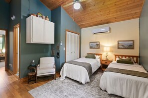A room with two beds, a chair, a wardrobe, and an air conditioning unit. - Cozy Skylodge, Lake, Hot Tub, Mountain View, Games (Canton)