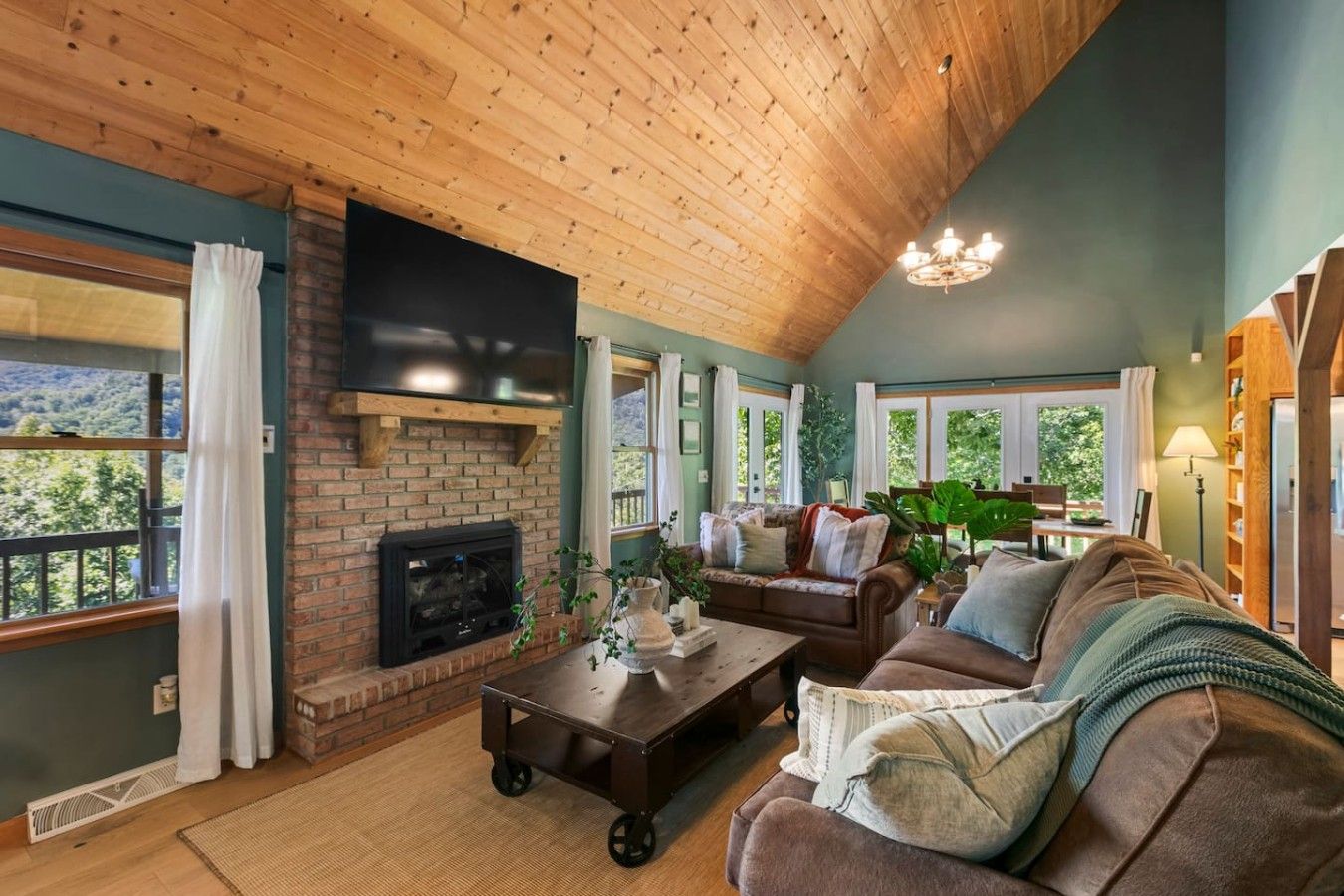 A cozy living room with a fireplace, a large flat-screen TV, and a comfortable seating area.