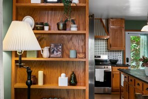 Een keuken met houten planken, een lamp en een fornuis.