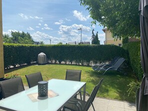 A patio area with a table and chairs, a covered grill, and a lawn chair. - Holiday Home Moseltraum (Dieblich)