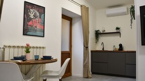 A modern kitchen with a dining area, featuring a radiator, a sink, and a potted plant. - Fly&Rest MXP | Unit 1 | 24/7 Airport Transfer (Casorate Sempione)