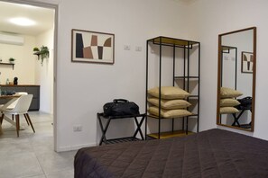A hotel room with a bed, a desk, a chair, a wardrobe, and a mirror.